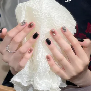 Handmade press-on nails in obsidian black and milk tea brown with rhinestone stars