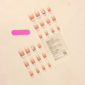 Detailed set of 24 gradient french tip press-on nails with rhinestone accents and accessories