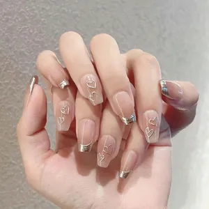Close-up of nude pink press-on nails with silver metallic French tips and heart details