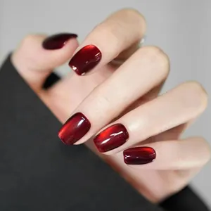 Detail of dark wine red cat eye press-on nails with velvet magnetic effect and glossy finish