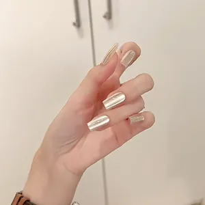 Macro view of long coffin-shaped silver cat-eye magnetic press-on nails on hands