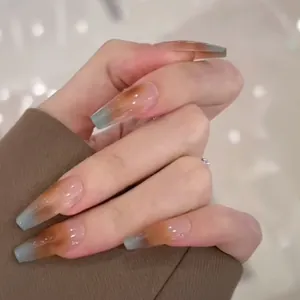 Macro side view of long coffin amber gradient press-on nails on hands with clear details
