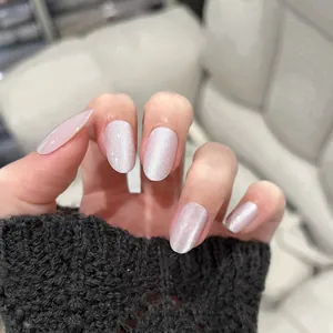 Detail of pearlescent cat-eye press-on nails in cream white and soft pink finish