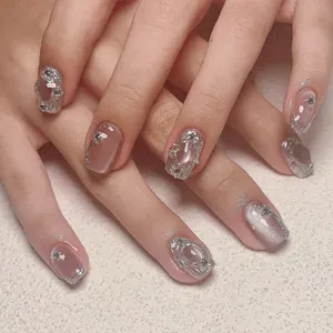 Detail of pink cat eye nails with 3D liquid metal accents and rhinestones on hands