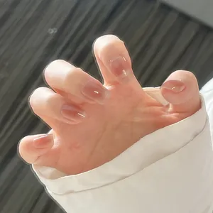 Detailed close-up of glossy nude pink square-oval press-on nails with jelly texture