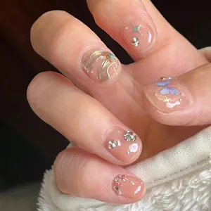 Detailed macro shot of handmade press-on nails with silver stars and butterfly gems