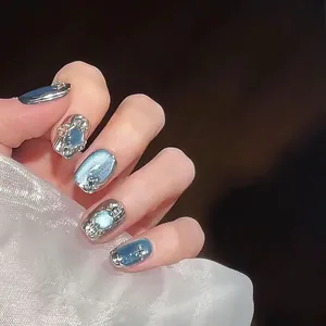 Close-up of galaxy-style cat eye press-on nails with silver metallic accents and pearls