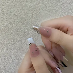 Long trapezoid press-on nails with nude pink base, silver stars and rhinestones