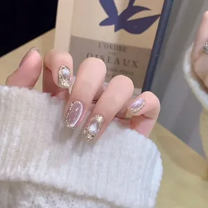 Detailed view of champagne gold glitter and silver cat-eye press-on nails on a model