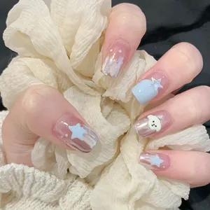 Detail of pink press-on nails featuring 3D blue stars and a cute white bear design