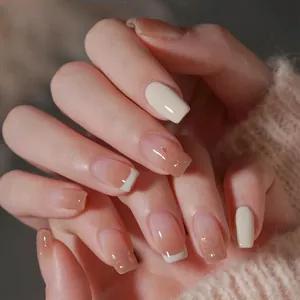 Detail of short square press-on nails with nude gradient and French white tip design