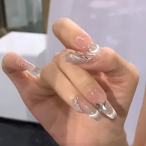 Macro shot of long coffin press-on nails with silver butterfly charms and cat eye glitter