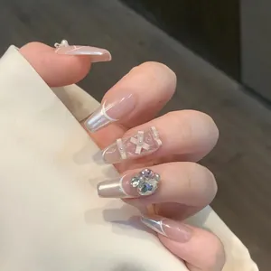 Details von langen Ballerina-Nägeln mit 3D-Schleife, Perlen und Herz-Strasssteinen im Set