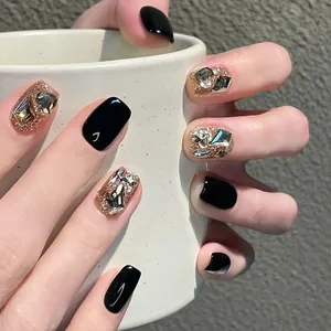 Detailed view of short square press-on nails with black finish, rose gold glitter and rhinestones