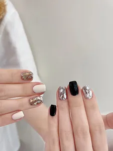 Detail von eleganten schwarz-weißen Press-On-Nägeln mit Glitzersteinen und silbernem Glitter