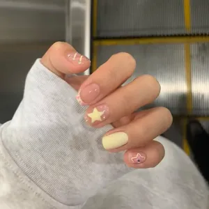 Schattige French press-on nagels met sterrenpatroon in zachtgeel en roze met glitters