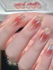 Nahaufnahme von langen Trapez-Kunstnägeln mit rosa Farbverlauf und glitzerndem Dekor
