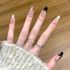Detailed view of long coffin nails with nude pink base, black French tips and silver glitter