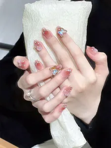 Nahaufnahme von rosa Gradient-Nägeln mit 3D-Schmetterlingen, Rosen und Perlen