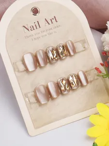 Detail of pink cat-eye press-on nails with golden glitter and sparkling rhinestones