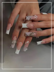 Detail of long French press-on nails with 3D white flowers and silver butterfly charms