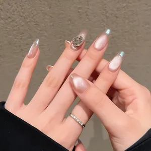 Detail of pink cat eye press-on nails with silver French tips and rhinestone accents