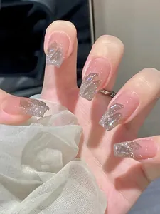 Detail von rosa Press-on-Nägeln mit silbernem Glitzer und 3D-Schleifenstruktur im Sarg-Stil