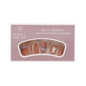 Press-on nail set featuring nude gradient, glitter, and pearls in purple packaging box