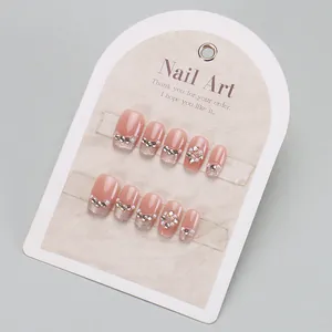 Short square nude pink press-on nails with cat-eye glitter, pearls and rhinestones