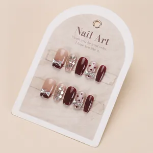 Handmade cat-eye press-on nails with red polka dots and silver bow rhinestones