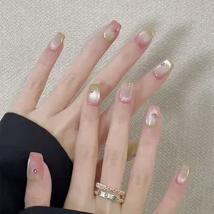 Cat eye press-on nails with pink gradient and small rhinestone accents on square tips