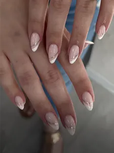 Dettaglio di unghie a mandorla con base nude, punte french bianche e linee sottili argento