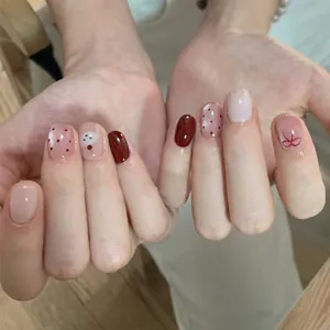 Short round red cat-eye press-on nails with cute bow, polka dots and cloud designs