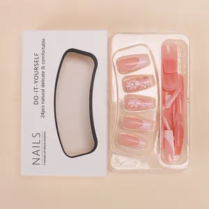 Medium length pink gradient press-on nails with white flower motifs and crystal accents