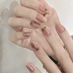 Faux ongles élégants avec feuilles dorées et baies rouges sur base nude translucide