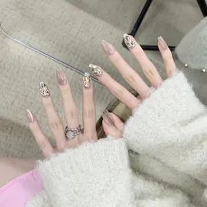 Champagne cat eye press-on nails with luxury 9K rhinestones and pearls on model