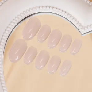 Détail de faux ongles dégradés rose nude avec finition brillante et forme ovale