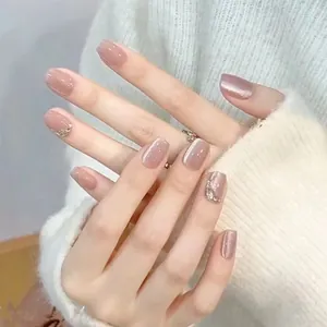 Unghie finte rosa occhio di gatto con strass scintillanti e design elegante di perle