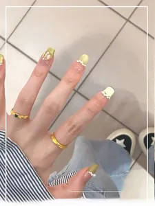Détails d'ongles French cat eye jaune fluo avec perles et décoration en pierre précieuse