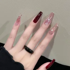 Burgundy and nude pink coffin press-on nails with 3D bows and rhinestone details