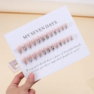 Pink ombre press-on nails with silver glitter tips and rhinestone accents on display card