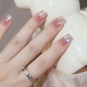 Handmade gradient nude pink press-on nails with glitter and rhinestones in short square shape
