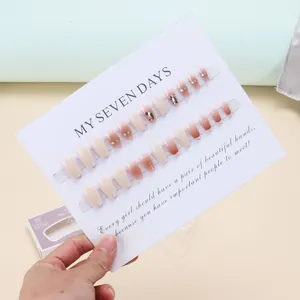 Uñas postizas blanco crema estilo francés con pedrería y acabado efecto espejo