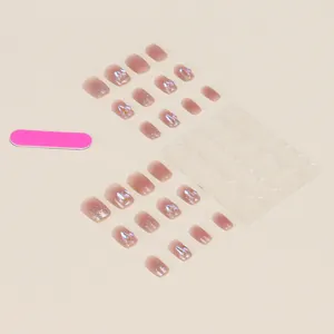 Flat lay of pink-purple gradient press-on nails with 3D rhinestones and tool kit