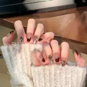 Detail of press-on nails with dark red French design and luxury rhinestone accents