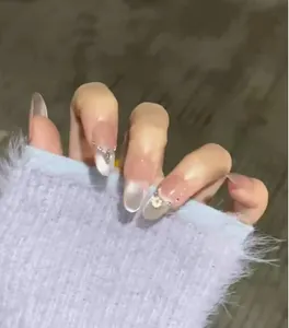 Detail of pink gradient cat-eye press-on nails with rhinestone and flower accents