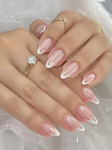 Macro detail of almond-shaped French nails with nude base and silver glitter V-tips