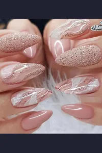 Detail of almond press-on nails with rose gold glitter and marble texture on white fur