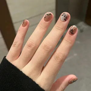 Brown cat-eye press-on nails with silver glitter and black leaf patterns, short round shape