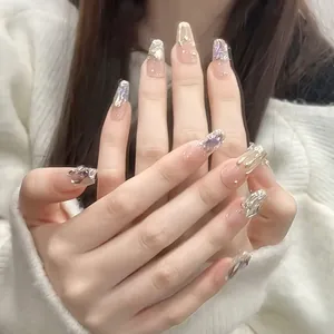 Detail of nude pink coffin press-on nails with silver 3D relief and purple glitter